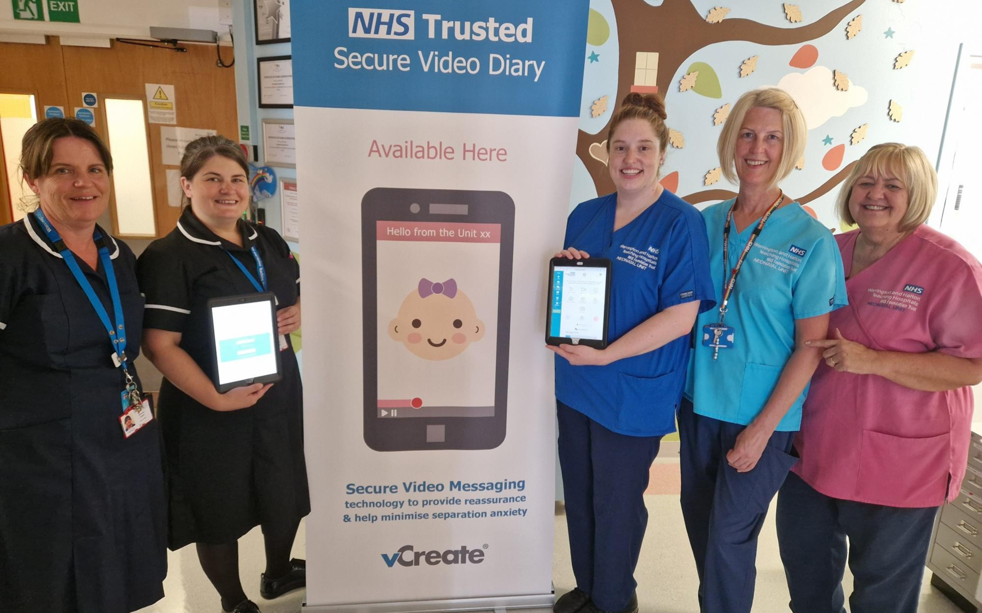 Five neonatal staff with tablets showing the digital video diaries.