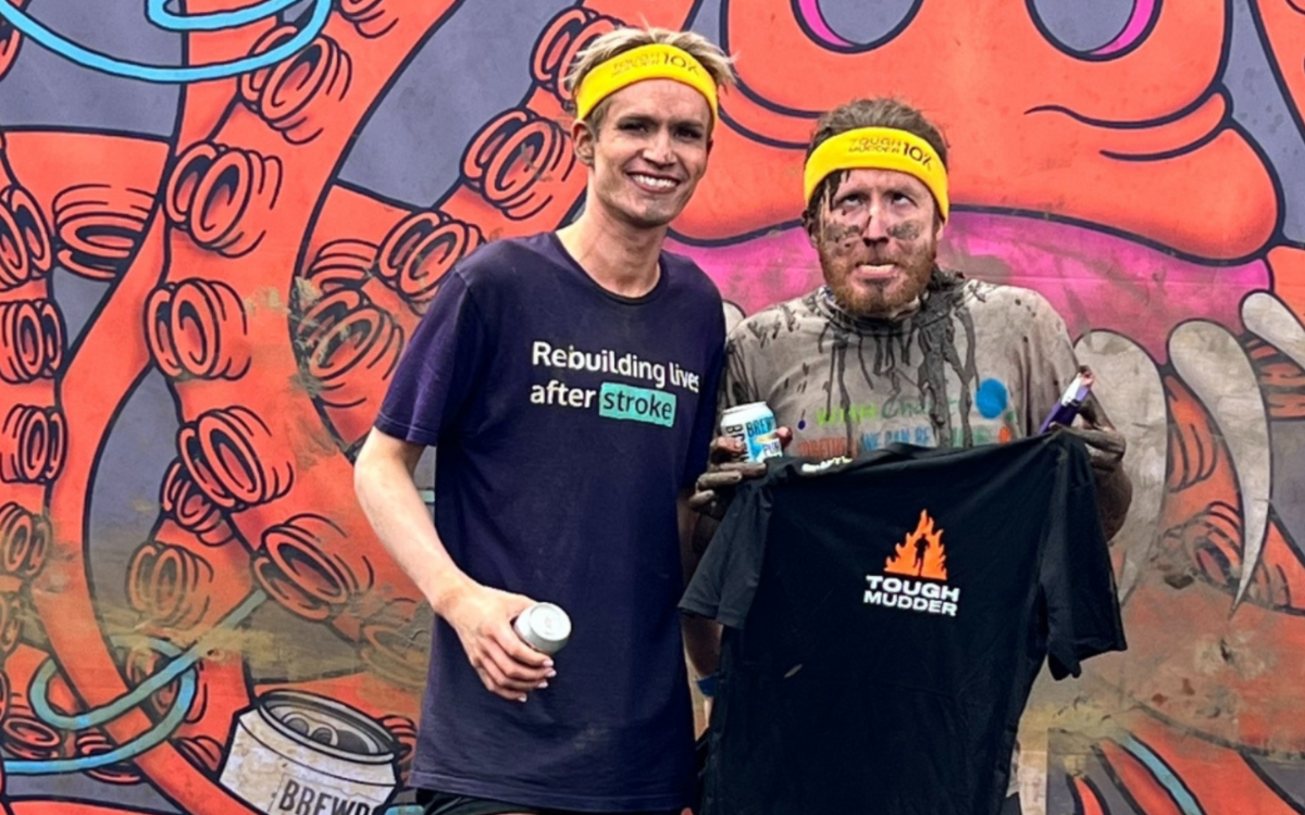 Two people full of mud after taking part in a fundraising challenge.