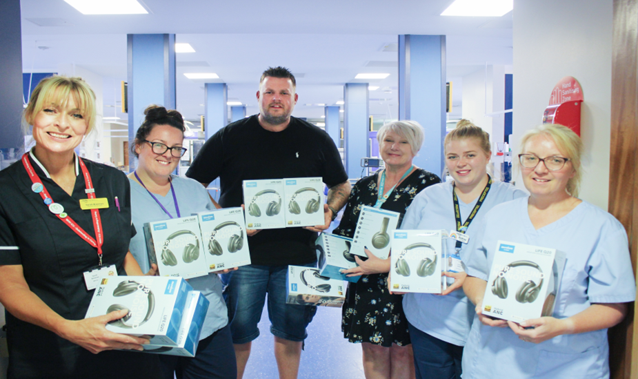 Laurence presenting headphones to staff on the Intensive Care Unit at Warrington Hospital.