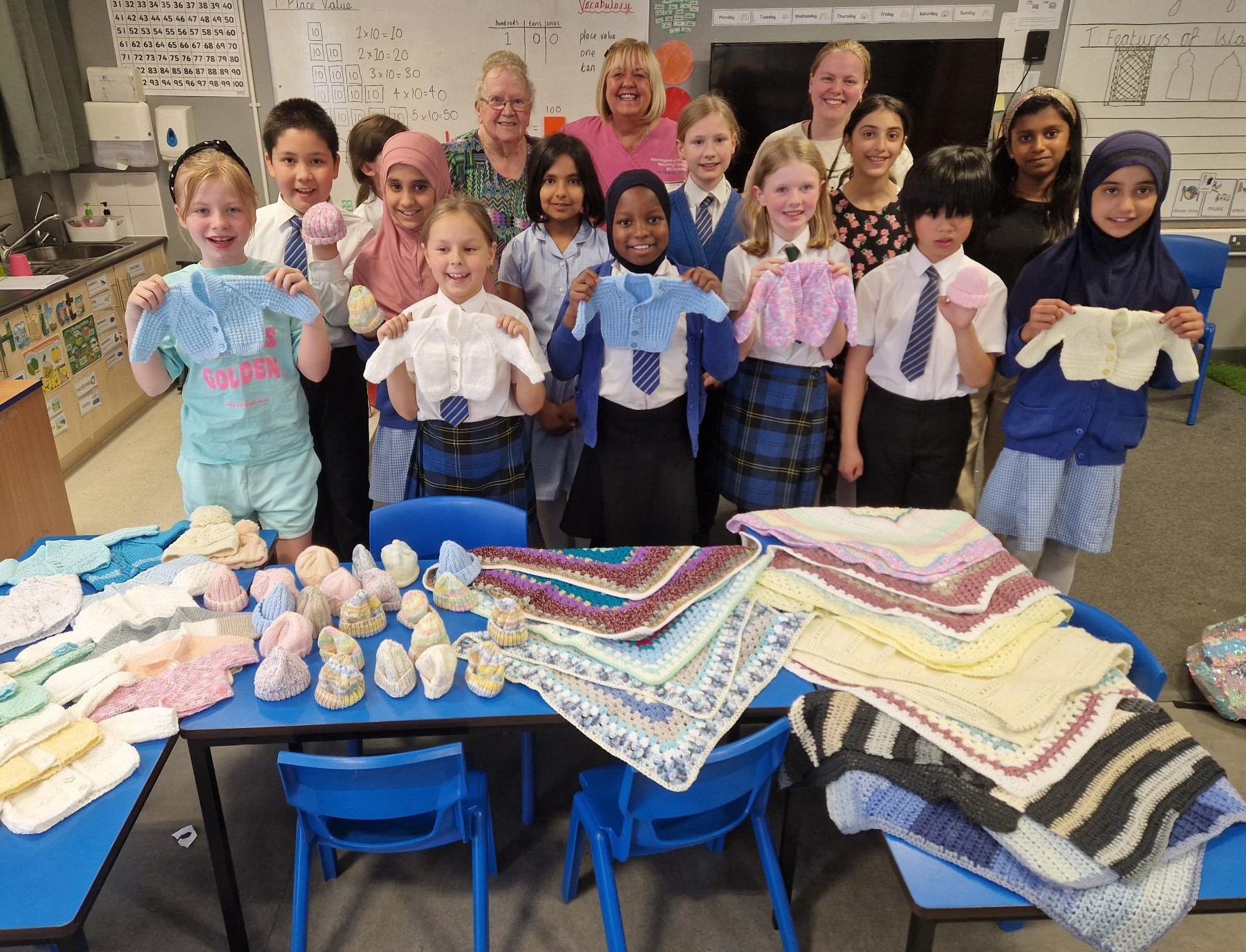 School group showing their knitted items which will support neonatal babies.